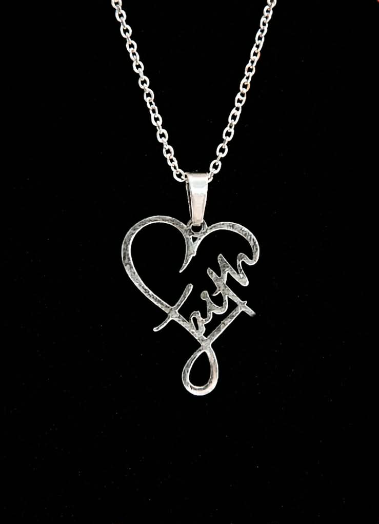 Silver necklace with a heart-shaped pendant featuring the word 'Faith' on a black background