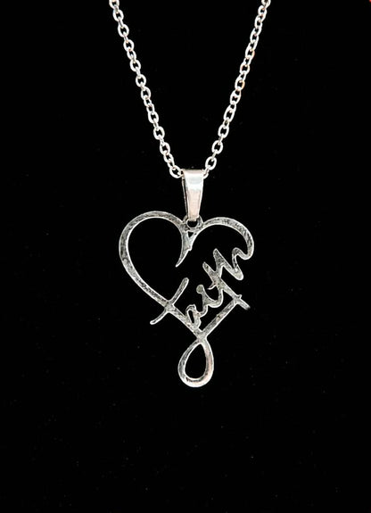 Silver necklace with a heart-shaped pendant featuring the word 'Faith' on a black background