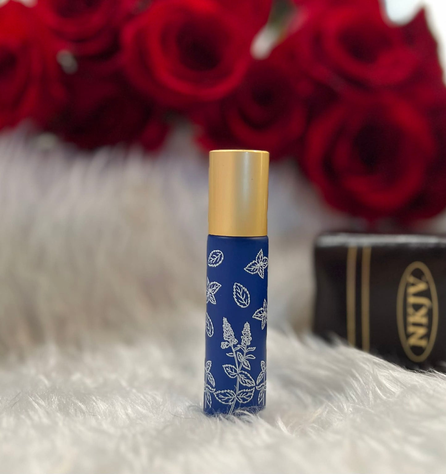 Blue glass anointing oil roller bottle with white decorative design