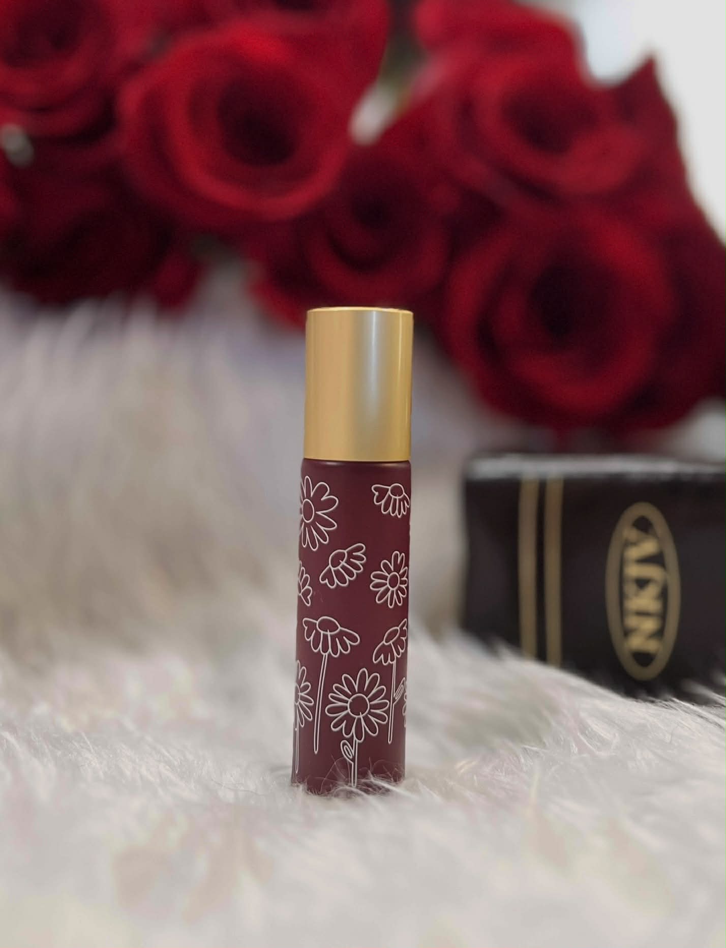 Deep red glass anointing oil roller bottle with white decorative design