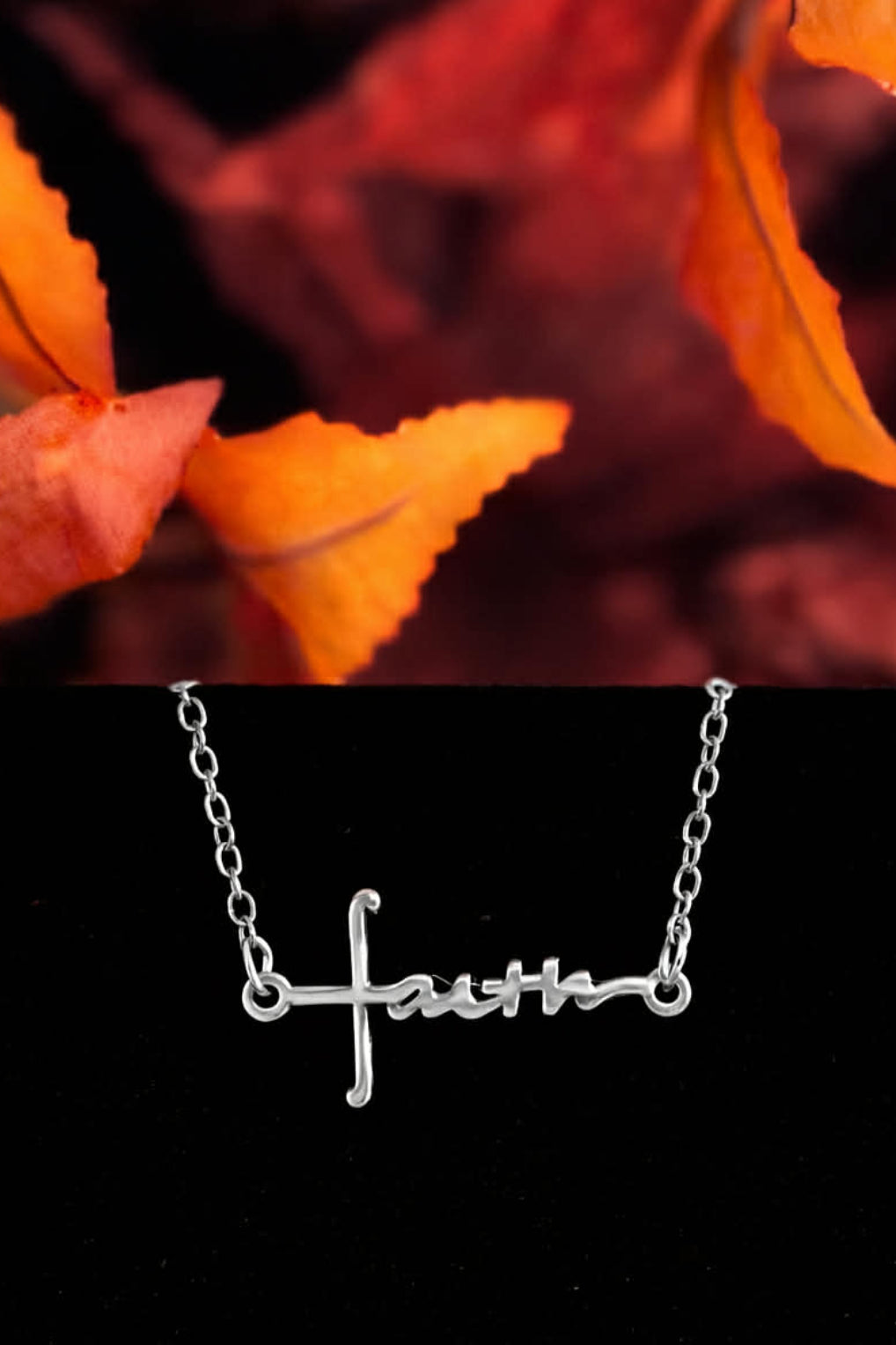 Silver Faith script cross bracelet displayed with autumn leaves