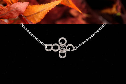 Silver God Is Good Christian bracelet displayed with autumn leaves.
